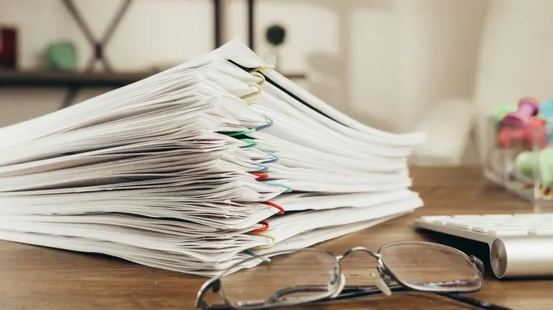 Stack of legal documents organized for claim filing